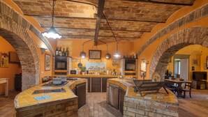 Une cuisine avec des arches en briques, un îlot central et un luminaire suspendu.