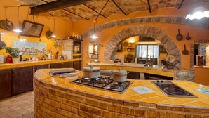 Une cuisine avec une arche en briques, des plans de travail recouverts de carreaux jaunes et une cuisinière à gaz.