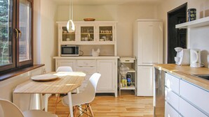 Eine moderne Küche mit weißen Schränken, einem Holztisch und Stühlen.