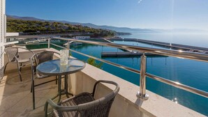 Una terraza con vistas a un puerto deportivo y montañas.