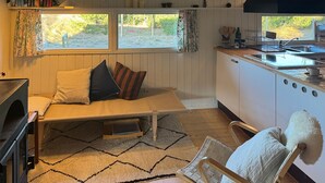 A cozy room with a bed, a chair, a kitchen area, and a view of the outdoors. - 2 bedroom nice home in Fanø (Fanø)