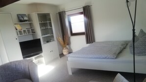 A compact room with a bed, a sofa, a TV, and a small table. - Holiday Bag WE1468 - Holiday Home (Sassnitz)