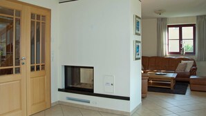 A living room with a fireplace, a sofa, a coffee table, and a door with glass panels.