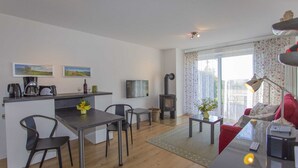 Een moderne woonruimte met keuken, eethoek en een gezellige zithoek met open haard.
