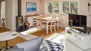 Une cuisine moderne dotée d’une cuisinière intégrée, de meubles en bois et d’un coin repas avec une table et des chaises.