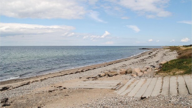 A beach with a pebble path leading to the water, a clear sky, and distant land. - 1 bedroom lovely home in Kalundborg (Kalundborg)