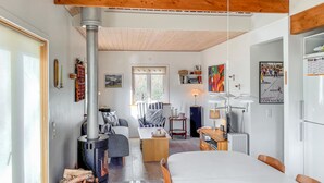 A cozy living room with a fireplace, a dining area, and a kitchen with a modern stove. - 1 bedroom lovely home in Kalundborg (Kalundborg)