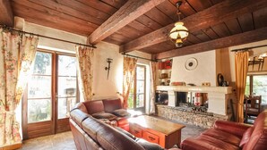 A cozy living room with a leather sofa, a wooden coffee table, and a fireplace. - Awesome home in La Roquette sur Siagne (La Roquette sur Siagne)