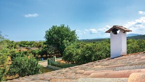 A white building with a small tower on a tiled roof, surrounded by greenery and a clear sky. - Beach front home in Porto Cristo (Porto Cristo)
