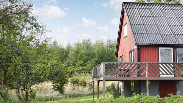 A red building with a balcony, surrounded by greenery and trees. - 2 bedroom beautiful home in örkelljunga (Örkelljunga)