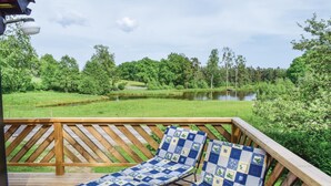 A deck with two lounge chairs and a view of a lake surrounded by trees. - 2 bedroom beautiful home in örkelljunga (Örkelljunga)