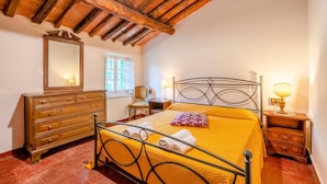 Une chambre à coucher avec un lit, une commode en bois et un miroir.