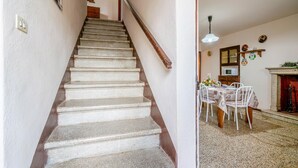 Un escalier menant à une salle à manger équipée d’une table et de chaises.
