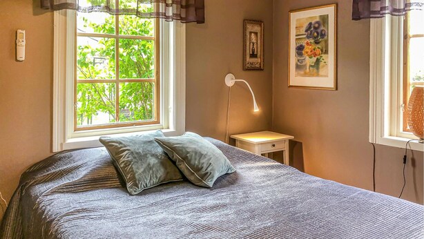 A bedroom with a bed, a bedside table, a lamp, and two framed pictures on the wall. - Stunning home in Tingstäde with WiFi (Tingstäde)