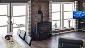 A cozy living room with a fireplace, a dining table with chairs, and a television. - Lovely home in Rauland with sauna (Rauland)