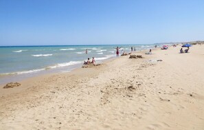 A sandy beach with people sunbathing and swimming. - Stunning home in Rojales (Rojales)