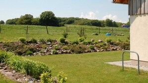 A rural house with a garden and a fenced field. - Apartment Anna - House Uhleck (Lohme)