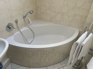 Ein modernes Badezimmer mit freistehender Badewanne, einem wandmontierten Waschbecken und einem Handtuchhalter.