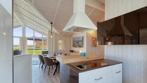 Una cocina moderna con una isla central, ventanas amplias y vistas al exterior.