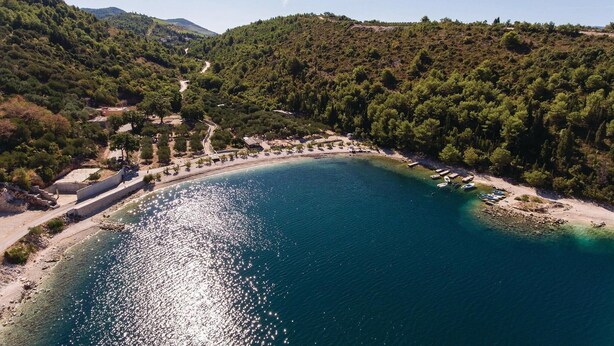 An aerial view of a coastal area with a clear blue sea, surrounded by dense green hills and a winding road. - 6 bedroom accommodation in Klek (Klek)