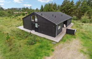 Enjoy expansive forest views from the large windows of this two-story cabin, featuring a spacious deck area for outdoor activities.