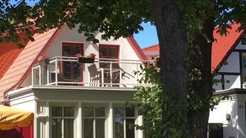 Enjoy a tranquil retreat with a balcony offering views of the surrounding area and a covered porch for relaxation amidst lush greenery.