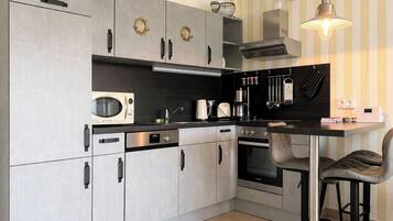Een koffiezetapparaat/waterkoker, een koelkast, een magnetron, een oven