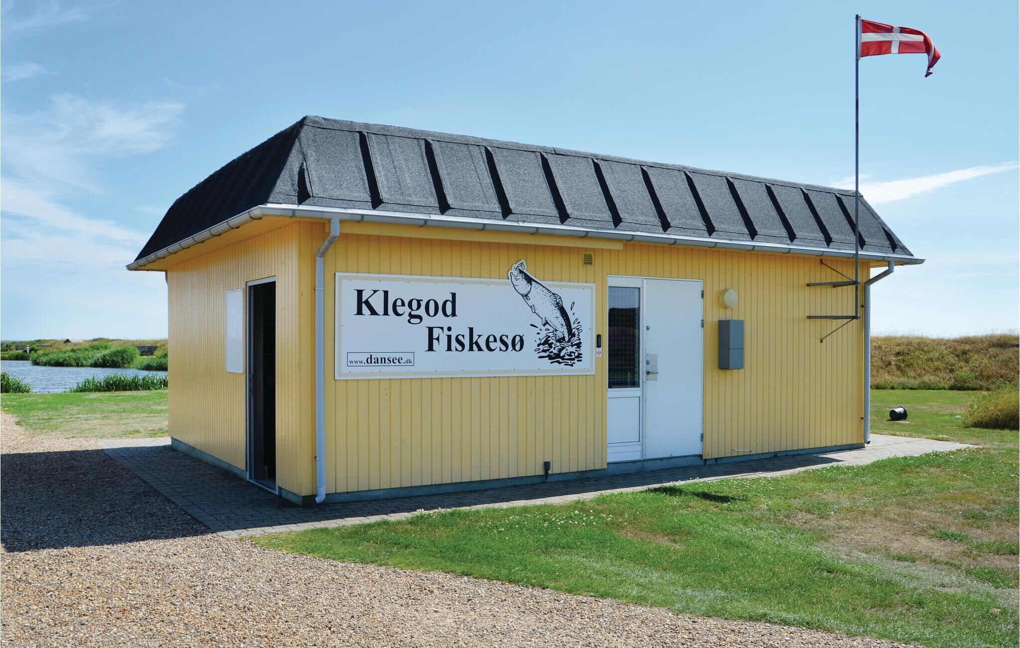 A yellow building with a sign reading "Klegod Fiskeso" and a flag on top.
