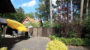 A patio area with a brick floor, outdoor furniture, and a yellow umbrella. - Apartment 2.4 - 55sqm with fireplace and 2 bedrooms - ADS apartments **approx. 20 (Ückeritz)