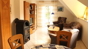 A cozy living room with a fireplace, a television, and a comfortable seating area. - Apartment 2.4 - 55sqm with fireplace and 2 bedrooms - ADS apartments **approx. 20 (Ückeritz)