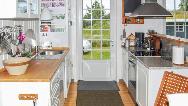 A kitchen with a large window, a sink, a stove, and various kitchen utensils. - Amazing home in Rømø with WiFi (Rømø)