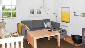 A modern living room with a grey sofa, a wooden coffee table, and a black bucket. - Amazing home in Rømø with WiFi (Rømø)