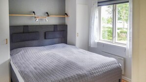 A bedroom with a bed, a headboard, a window, and a radiator. - Nice home in Långaryd with WiFi (Långaryd)
