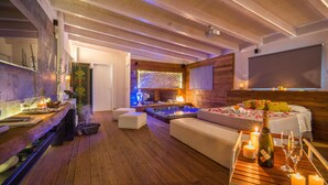 A cozy room with a wooden floor, a hot tub, a sofa, and a bar area with candles and a bottle of wine. - 1 bedroom gorgeous home in Palermo (PA) (Palermo (PA))
