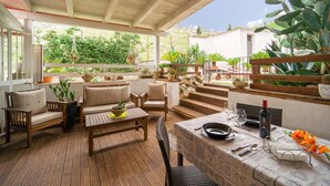 An outdoor patio with wooden furniture, a table set for dining, and various potted plants. - 1 bedroom gorgeous home in Palermo (PA) (Palermo (PA))
