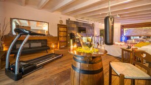 A room with a treadmill, a punching bag, a wooden barrel, and a cozy seating area with a sofa and a chair. - 1 bedroom gorgeous home in Palermo (PA) (Palermo (PA))
