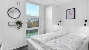 A white room with a bed, a window, a mirror, and a framed picture. - Pet friendly home in Vestervig with sauna (Vestervig)