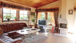 Ein gemütliches Wohnzimmer mit Ledersofa, Fernseher und Kamin.