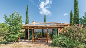 A modern house with a tiled roof, large windows, and a patio with wooden furniture. - Beautiful home in Capmany (Capmany)
