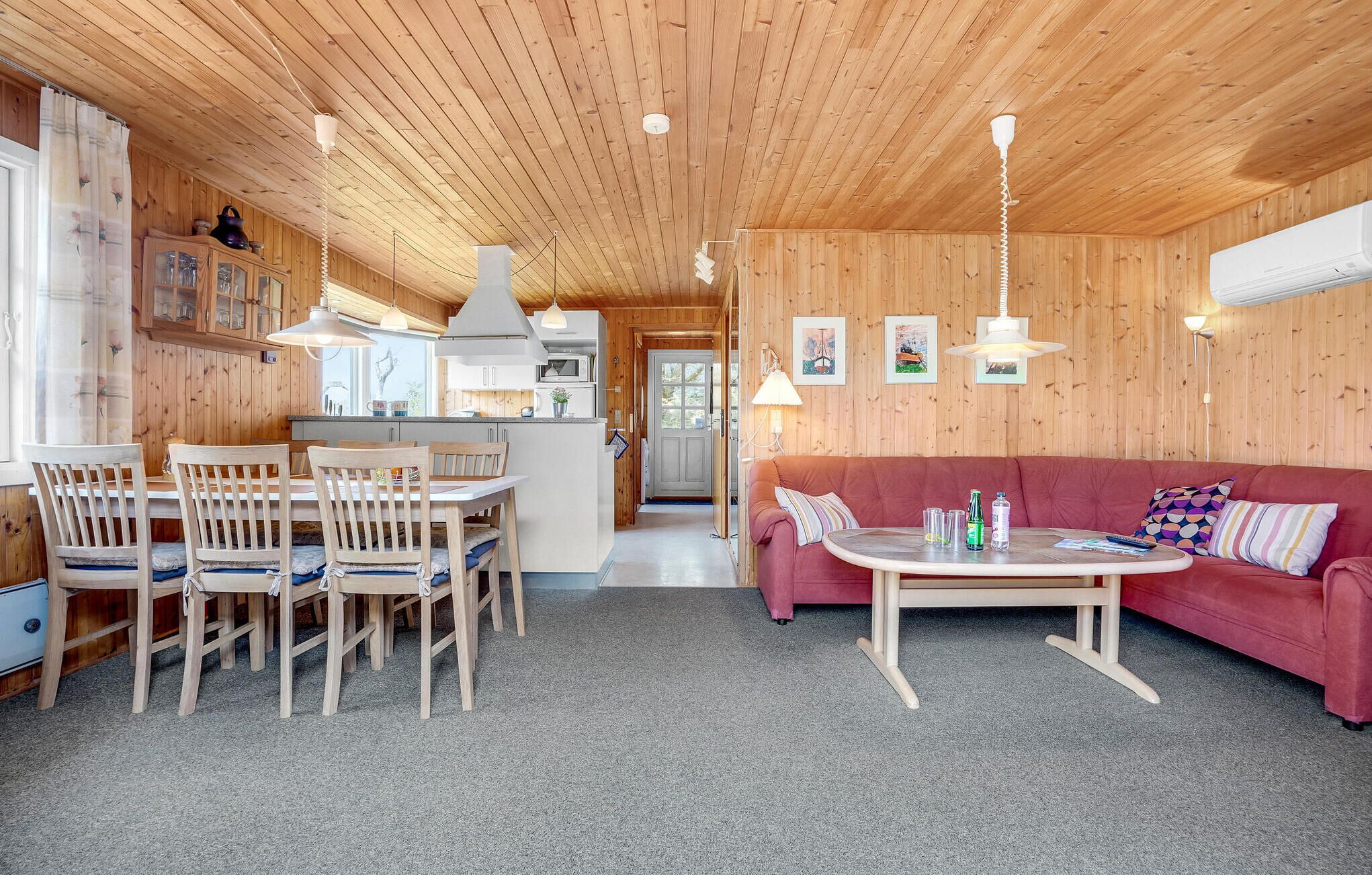 Ein gemütliches Holzinterieur mit Essbereich, einer Couch und einer Küche.