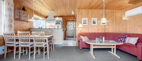 Ein gemütliches Holzinterieur mit Essbereich, einer Couch und einer Küche.