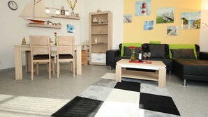 Un salon moderne comprenant un coin repas, une bibliothèque et une table basse.