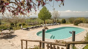 A pool area with lounge chairs, a dining table, and a view of the landscape. - Lovely home in Collevecchio (RI) with sauna (Collevecchio (RI))