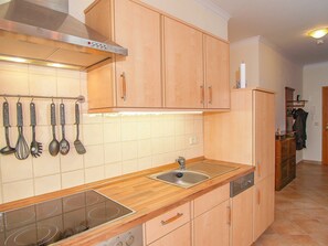 Une cuisine avec des meubles en bois, un évier en acier inoxydable et une hotte aspirante.