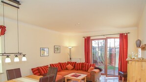 A living room with a sofa, chairs, a table, and a view through a glass door to the outside. - Residence Seestern Whg S-01 ..-See-01 (Kühlungsborn)