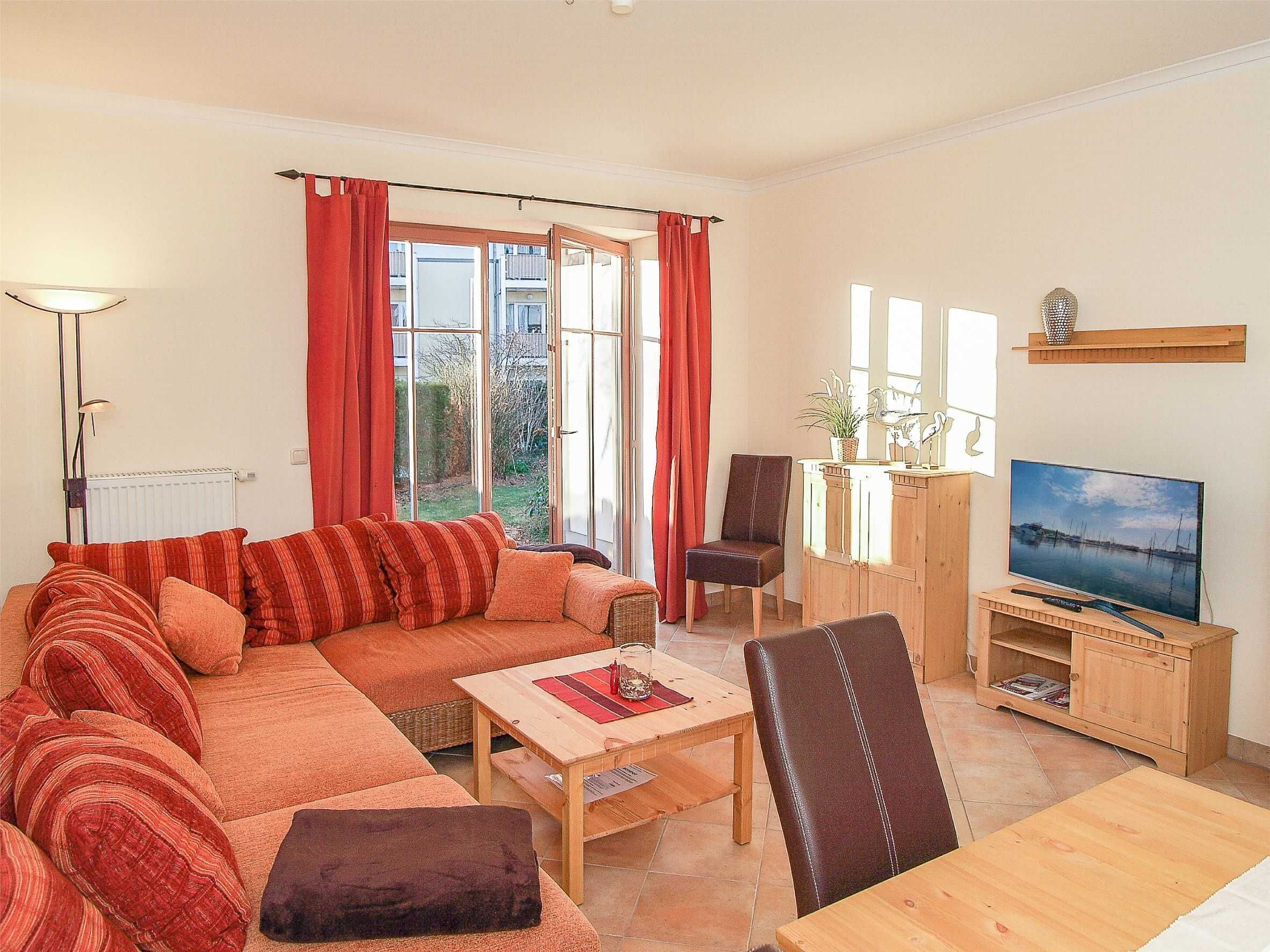 A living room with a sofa, a coffee table, a TV stand, and a chair.