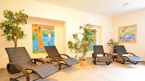 A room with four wicker lounge chairs, a potted plant, and two paintings on the walls. - Residence Seestern Whg S-01 ..-See-01 (Kühlungsborn)