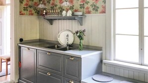 Uma cozinha com uma pia, um vaso com flores e uma janela.