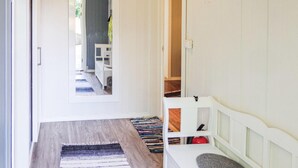A hallway with a wooden floor, a striped rug, and a white bench with a small shelf. - 5 bedroom amazing home in Matre (Matre)