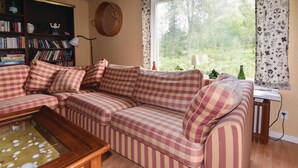 A cozy living room with a checkered sofa, a wooden coffee table, and a bookshelf filled with books. - 3 bEdroom pet friendly home in Ed (Ed)